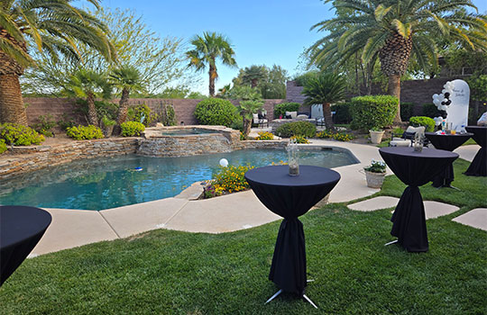 beautiful backyard with palm trees and inground pool with tables set up for catering by A Catered Affair
