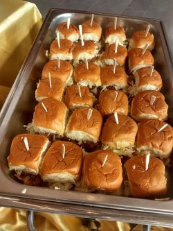A tray filled with mini sandwiches, each topped with a toothpick for serving.